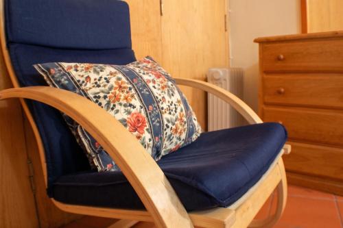 a wooden rocking chair with a blanket on it at Cosy apartment in Seia, 25 sqm, welcoming fireplace in Seia