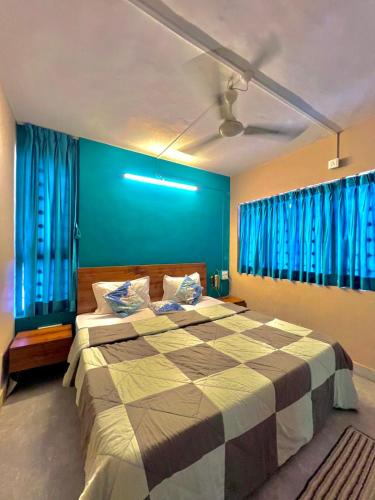 a bedroom with a large bed with blue curtains at Nature View Friends Villa - The Dream Stays ll Infinity Big pool ll 3Rooms ll Wi-Fi in Lonavala