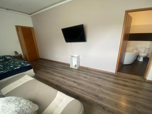 a bedroom with a bed and a tv on the wall at Tündér Pension in Mogyoród