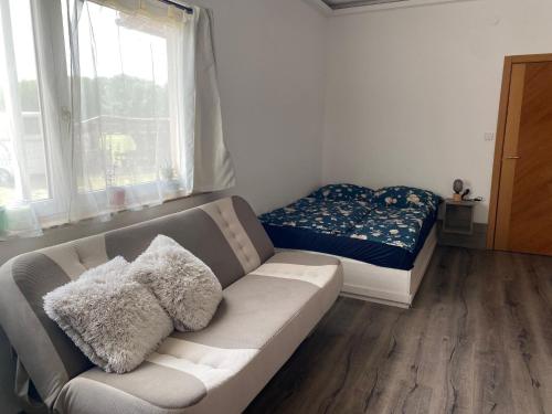 a living room with a couch and a bed at Tündér Pension in Mogyoród