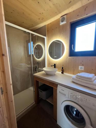 a bathroom with a washing machine and a sink at Lodges Au Cœur des Puys in Nébouzat