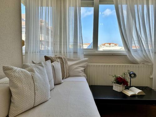 a bedroom with a white bed with a window at El Nido de Ris in Noja