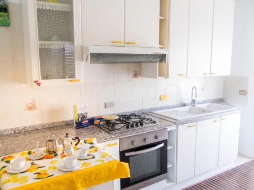 a kitchen with white cabinets and a stove top oven at Charming Apartment in Velina, 90 m², Mountain View in Castelnuovo Cilento