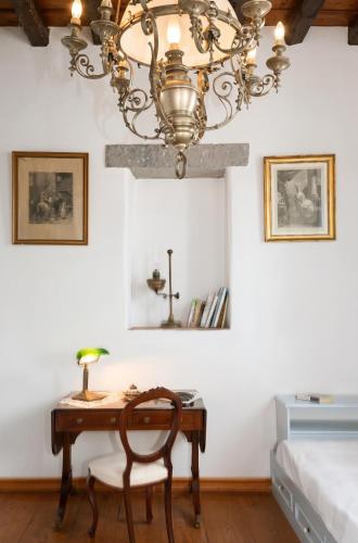 ein Schlafzimmer mit Schreibtisch und Kronleuchter in der Unterkunft Family House with Sea View in Patmos + Terrace in Patmos