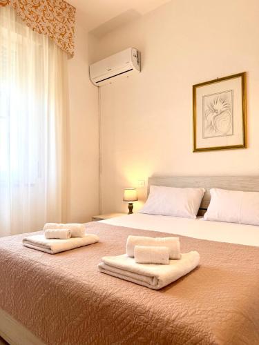 a bedroom with a bed with two towels on it at S'Olivare Posada - Apartment in Posada