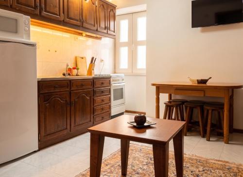 a kitchen with wooden cabinets and a table in it at Charming Apartment in Alvoco da Serra with Mountain View in Alvoco da Serra