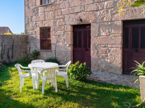 a table and chairs in front of a stone building at Charming Apartment in Alvoco da Serra with Mountain View in Alvoco da Serra