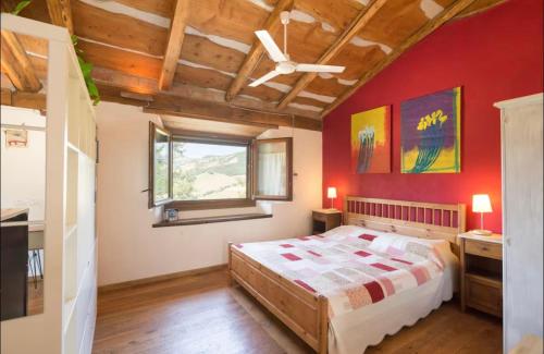 a bedroom with a bed and a red wall at Stonehouse LOFT MARTA in Vergato