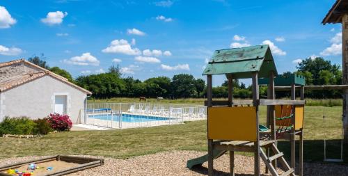 a playground with a slide next to a pool at Maison charmante à Saint-Vincent-la-Châtre avec piscine partagée in Saint-Vincent-la-Châtre