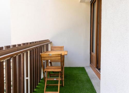 a wooden chair sitting next to a desk on a balcony at Appartement charmant à Briançon de 40 m² avec balcon in Briançon