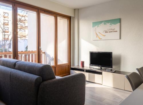 a living room with a couch and a television at Appartement charmant à Briançon de 40 m² avec balcon in Briançon