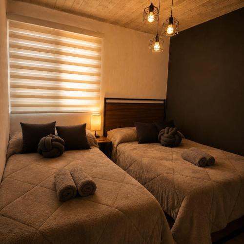 a bedroom with two beds with towels on them at Cabaña de lujo BlackMoon in Mazamitla