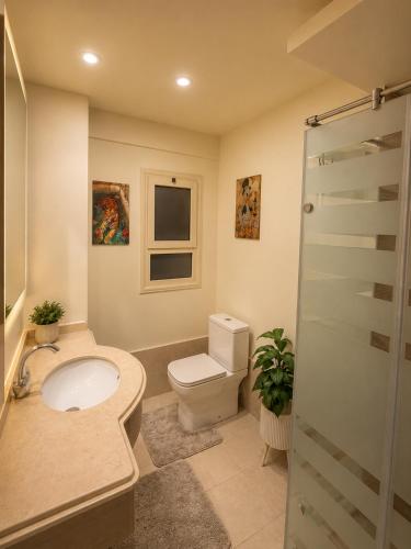a bathroom with a toilet and a sink and a shower at 1 BDR Pool Front Cozy Apartment in Port Ghalib