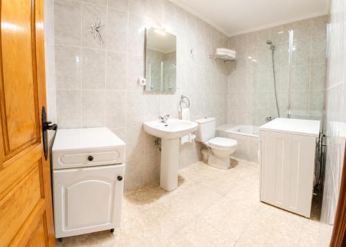 a bathroom with a sink and a toilet and a shower at Apartamento Cholo in Brañosera