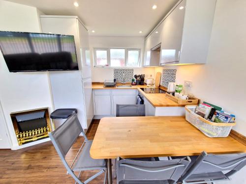 a kitchen with a large wooden table and chairs at 67 Broadside Holiday Chalet near Broads & Beaches in Stalham