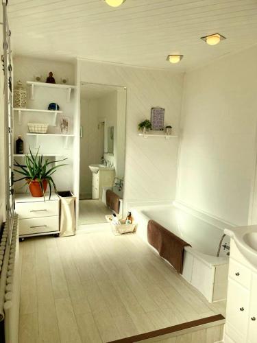 a white bathroom with a tub and a sink at Serenity Heights in Westgate-on-Sea