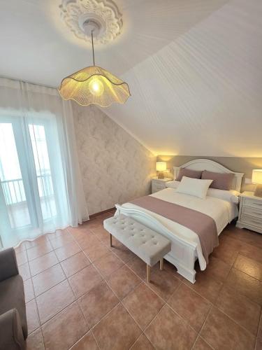 a bedroom with a large bed and a chandelier at Casa Zoila in Porto do Son