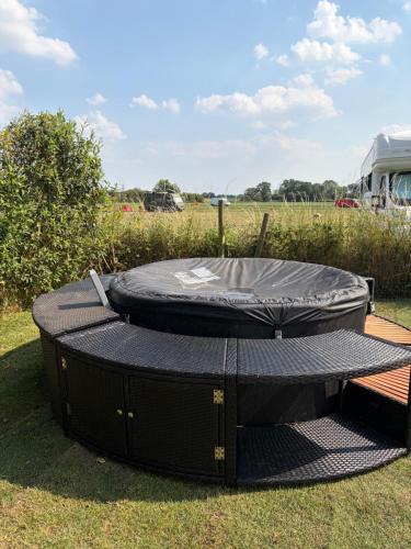 a trampoline with a cover on the grass at Camping at the Barge in Alton Barnes