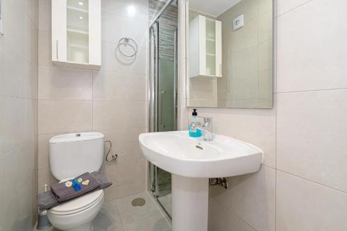 a white bathroom with a toilet and a sink at Appartement Capitolio Albir 1G in Albir