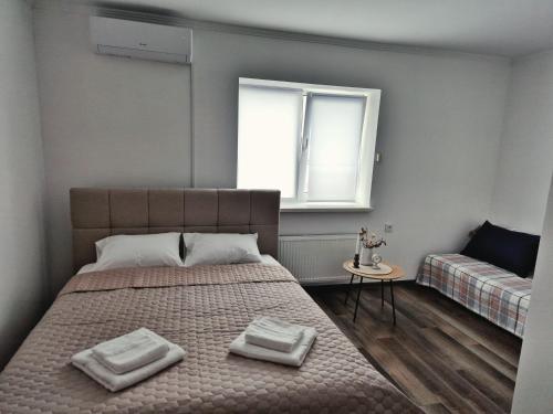 a bedroom with a bed with two towels on it at Zarvantsi Hotel in Khmelëva