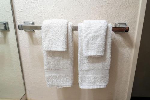 three towels hanging on a door in a bathroom at The Jeffreys Hotel Extended Stay in Osceola