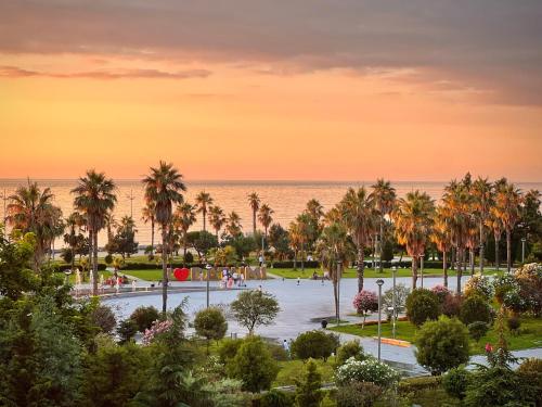 a view of a park with palm trees and the ocean at ibis Styles Batumi Hotel in Batumi