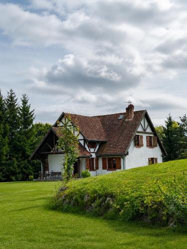 a house on top of a grassy hill at Siedlisko Mieruniszki in Mieruniszki
