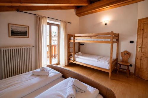 a bedroom with two bunk beds and a window at Appartamenti Pollam by AMA Val di Fassa in Pozza di Fassa