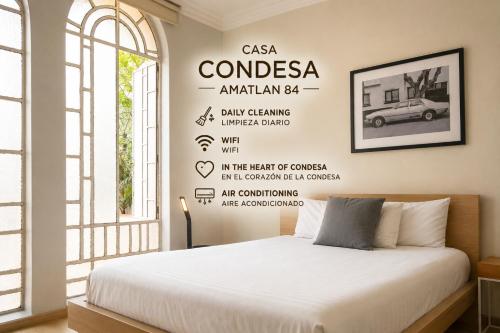 a bedroom with a bed with a poster of a car at Casa Condesa Amatlan 84 Hotel by Riberana in Mexico City