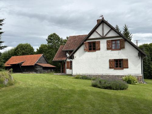 a white house with wooden windows and a yard at Siedlisko Mieruniszki in Mieruniszki
