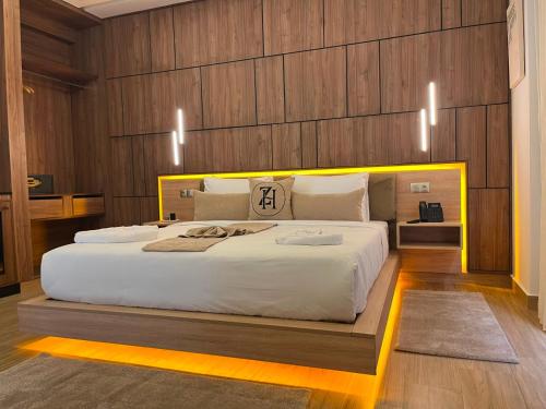 a bedroom with a large white bed with wooden walls at Dar Zaha in Aguenouane