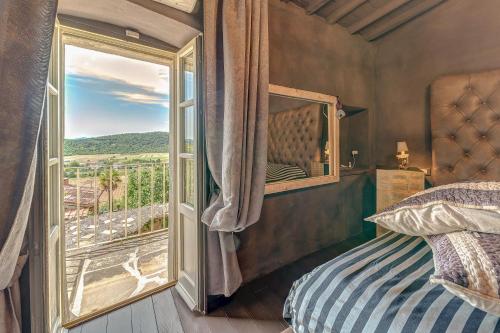 a bedroom with a bed and a large window at Antica Dimora in Capolona