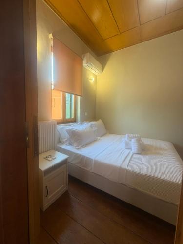 a small bedroom with a bed and a table at Apollon Heritage House in Palaiókipos