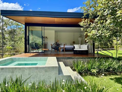 a modern house with a swimming pool in a yard at Arandu Bangalô in Cavalcante