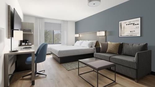 a hotel room with a bed and a couch at Hyatt Select Louisville North in Jeffersonville