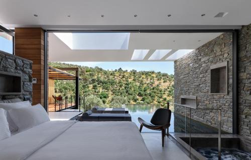 a bedroom with a bed and a balcony with a view at A - Luxury Villas in Plomari