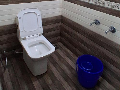 a bathroom with a toilet and a blue trash can at Venus Valley Vagamon in Vagamon