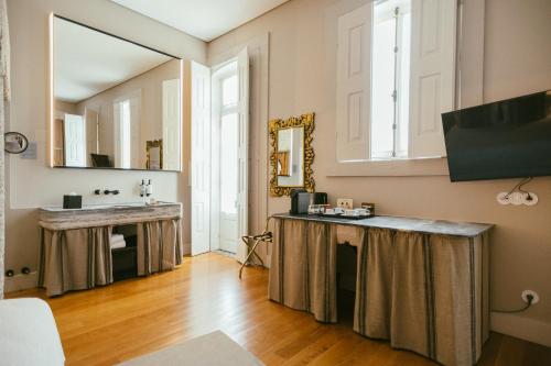 a bathroom with a sink and a mirror at Torel Royal Court in Guimarães