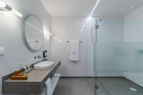 ein Badezimmer mit Waschbecken, Spiegel und Dusche in der Unterkunft SAL Collection Hotel in Aveiro