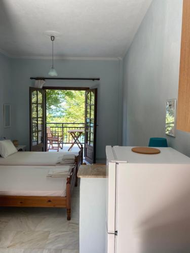 a bedroom with a bed and a refrigerator in a room at Paparizou Apartments in Kokkino Nero