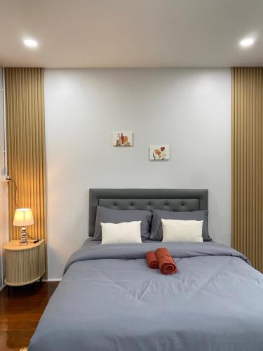 a bedroom with a blue bed with two red pillows at Rose & Nainee House Hatyai in Ban Tha Thon