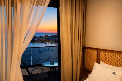 a room with a window with a view of the water at Oleva Sea View Suites in Sarandë