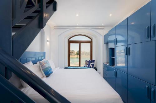 a small room with a bed and blue cabinets at VESTA - El Gouna Residence in Hurghada