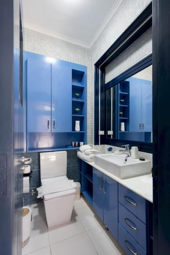 a blue bathroom with a toilet and a sink at VESTA - El Gouna Residence in Hurghada