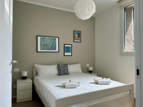 a bedroom with a white bed with two towels on it at Bressanone Apartments in Milan