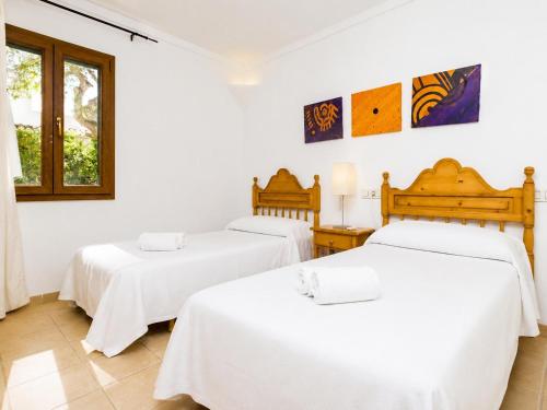 two beds in a room with white walls at Villa Binimelis in Cacla D'or