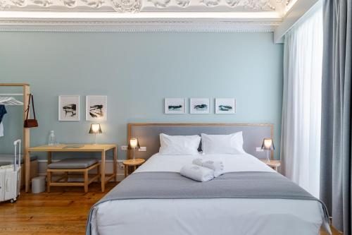 ein Schlafzimmer mit einem großen Bett, auf dem zwei Handtücher liegen in der Unterkunft SAL Collection Hotel in Aveiro