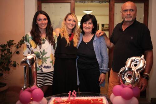 a group of people standing in front of a table with a cake at Casa de' Trinci in Foligno
