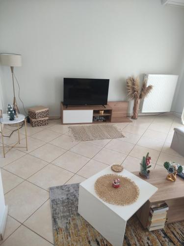 a living room with a tv and a table at Flat30 - Cosy apartment in Park of Kipseli- Xanthi in Xanthi