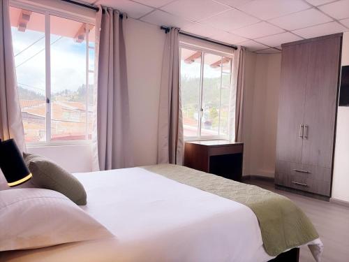 a bedroom with a large bed and a large window at Casa Herrerías Hotel & Confort in Cuenca